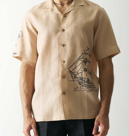 Beige shirt with ship design on a plain background