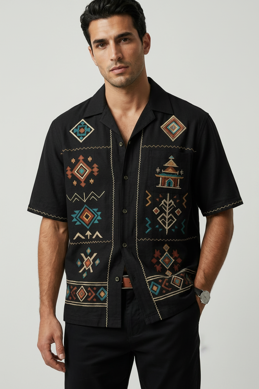 Man wearing a black shirt with colorful geometric patterns on a white background