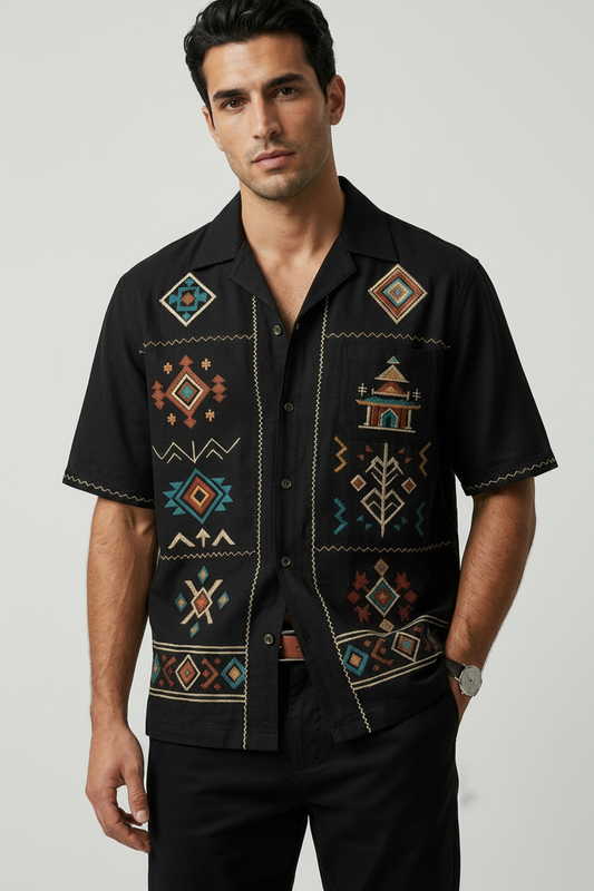 Man wearing a black shirt with colorful geometric patterns on a white background