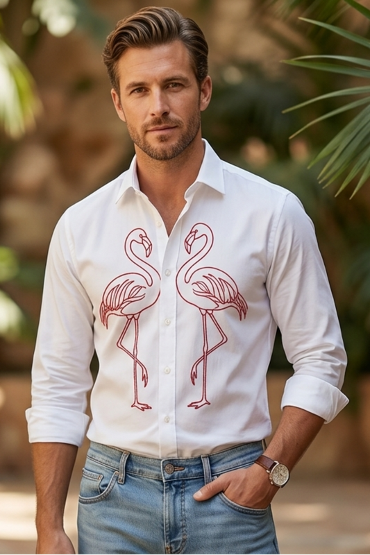 Man wearing a white shirt with flamingo design in a tropical setting