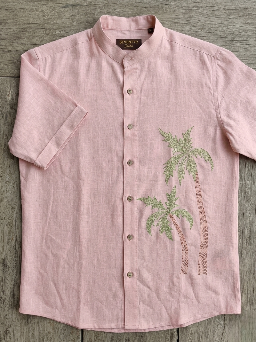 Pink shirt with palm tree design on a wooden surface