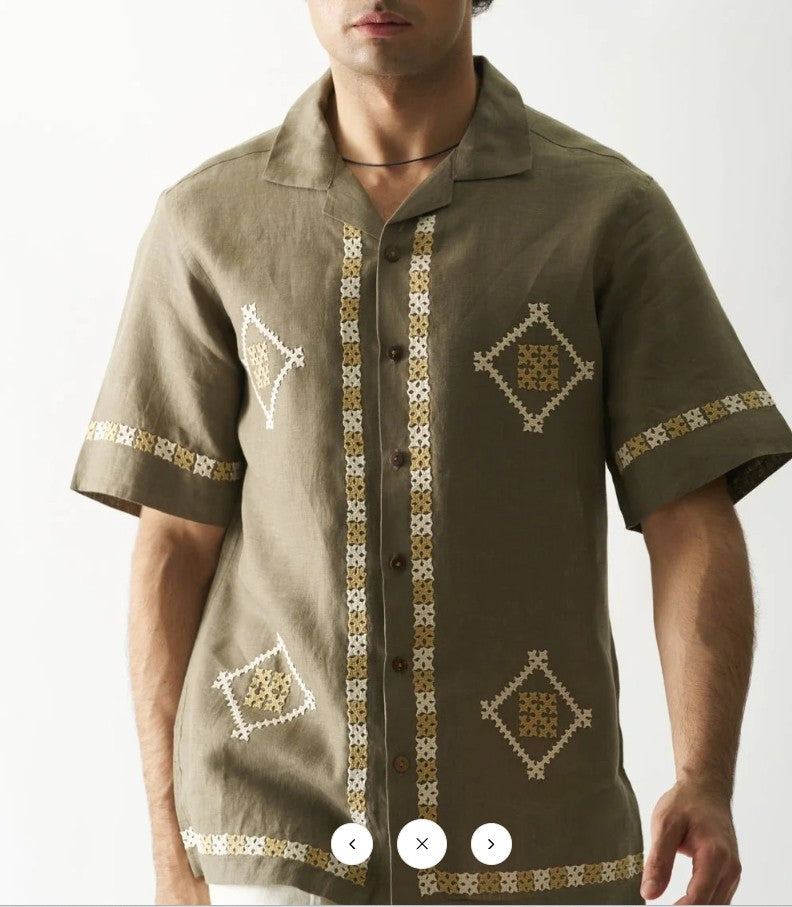 Man wearing a brown shirt with decorative patterns on a white background