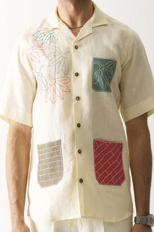 Beige shirt with floral and geometric embroidery on a white background